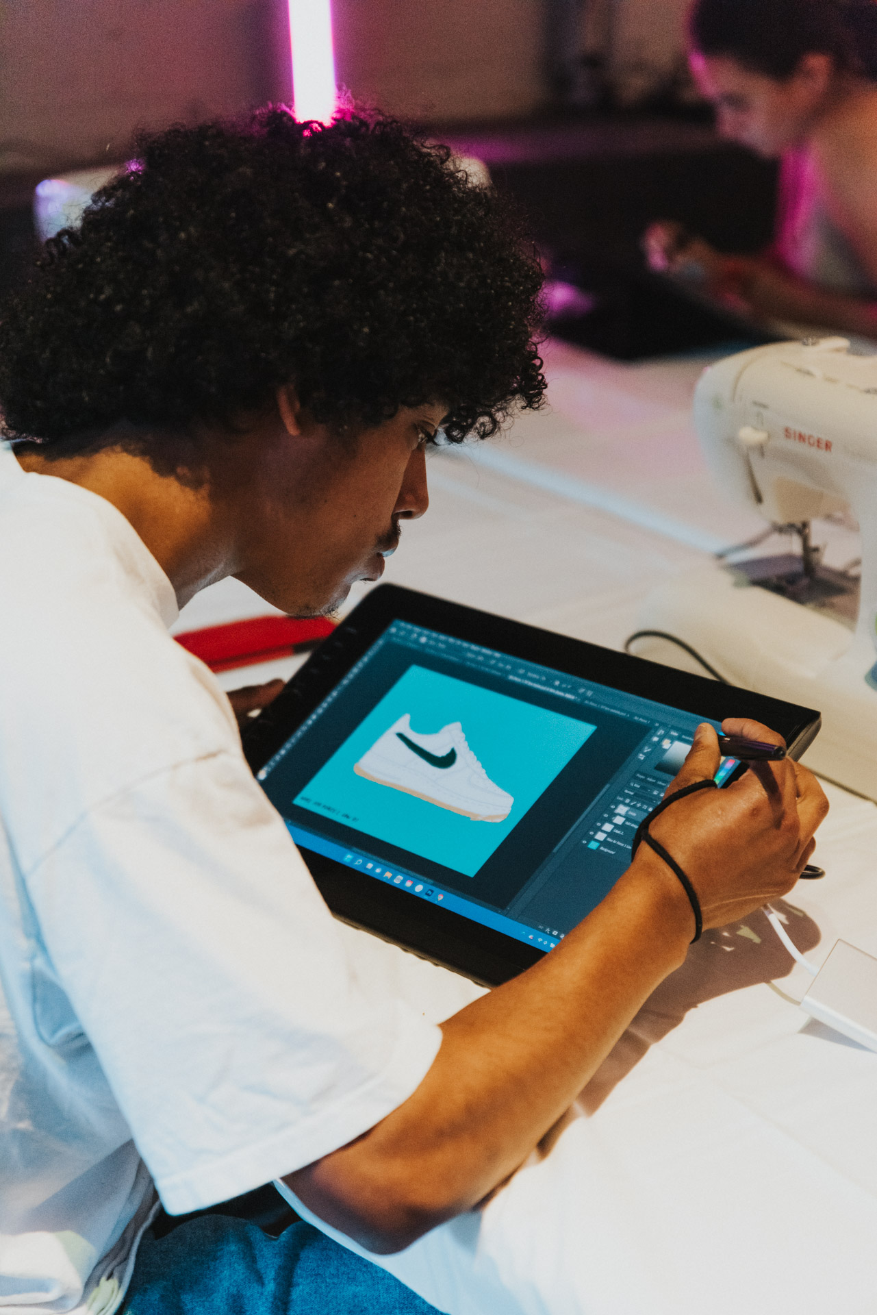 Designer sketching a sneaker on a digital tablet at a Knowledge Day workshop